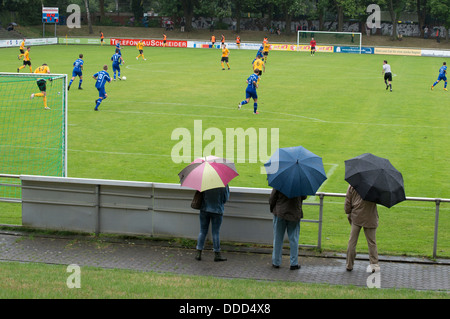 Fans von TuRU 1880 Düsseldorf stehen im Regen gerade ein Spiel gegen SV Honnepel-Niedermormter 18.08.13 (1-2) Stockfoto