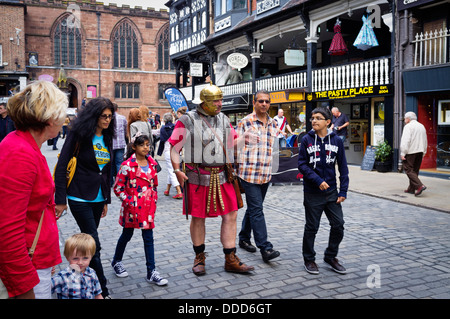 Ein Reiseleiter, gekleidet wie ein römischer Soldat nimmt eine Familie auf einer geführten Tour durch Chester, Cheshire, England, UK. Stockfoto