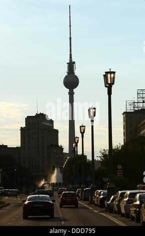 Autos fahren auf der Straße Karl-Marx-Allee in Richtung Strausberger Platz Square mit Ols Straßenlaternen und die TV Turm im Hintergrund, am Abend in Berlin, Deutschland, 28. August 2013. Foto: JENS KALAENE Stockfoto
