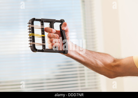 Mann mit Friedreich Ataxie mit deformierten Händen mit Hand Stärkung Ausrüstung Stockfoto