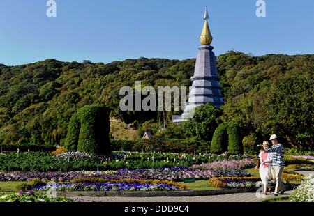 Ein junges Paar schlendern eines Gartenweges zusammen an den Twin Royal Stupas in Doi Inthanon Nationalpark Stockfoto