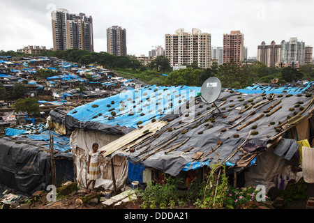 Ein junges Mädchen steht vor ihrem Haus fallenden Plastikplanen zum Schutz vor Monsun-Regen in den Slum in Mumbai, Indien Stockfoto