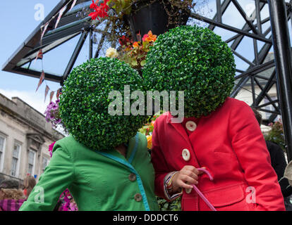 Runde, runde, grüne Kopfbedeckung, baumbestandene künstliche Perücken, Kopfanlage, getragen von Straßenkünstlern in Kendal, Cumbria, Großbritannien. August 2013. Mintfest, Kendal's International Festival of Street Arts, The Potheads by Let's Circus, Fat Face Shop, ein Lakes Alive Weekend Event im Lake District, bei dem einige der besten aus der ganzen Welt auftraten, zeitgenössischer Tanz, Zirkus, Comedy, Musik, Eigenartige Gruppe draußen auf den Straßen. Stockfoto