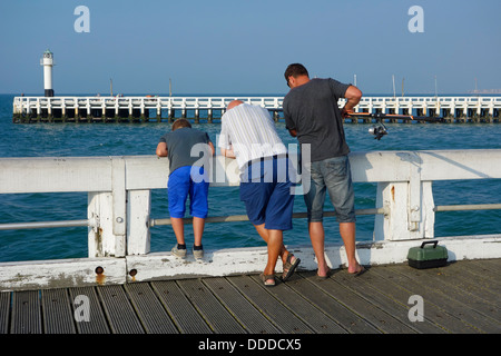 Sohn, Vater und Großvater Angeln mit Angelrute vom Pier entlang der Nordsee Küste in Nieuwpoort / Nieuport, Belgien Stockfoto