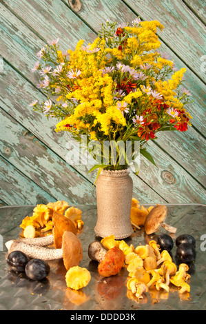 Stillleben mit gelben Blüten Bouquet mit Pilzen Stockfoto