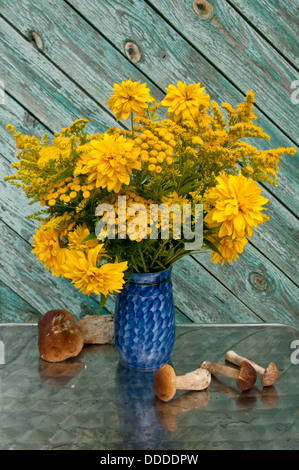 Stillleben-Bouquet von gelben Blüten und Boletus Edulis Pilze Stockfoto