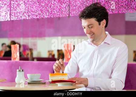 Junger Mann in einem Café oder Eis-Salon mit seinem Telefon, vielleicht ist er single oder jemand wartet Stockfoto