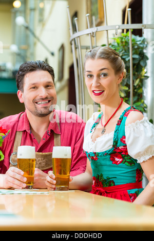 Junges Paar in der traditionellen bayerischen Tracht in Restaurant oder Pub mit Bier Stockfoto