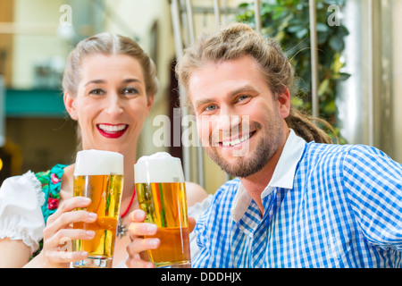 Junges Paar in der traditionellen bayerischen Tracht in Restaurant oder Pub mit Bier Stockfoto