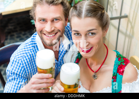 Junges Paar in der traditionellen bayerischen Tracht in Restaurant oder Pub mit Bier Stockfoto