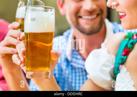 Freunde in traditioneller bayerischer Tracht in Restaurant oder Pub mit Bier Stockfoto