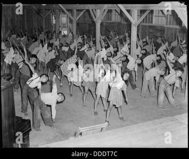 Kinder der zweiten Klasse im Jerome Relocation Center in Dermott, Arkansas, nehmen an rhythmischen Übungen Teil, die die täglichen Aktivitäten von internierten Kindern während des Zweiten Weltkriegs widerspiegeln Stockfoto