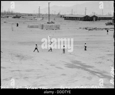 Die Jungen im Manzanar Relocation Center in Kalifornien beginnen kurz nach der Ankunft im Internierungslager während des Zweiten Weltkriegs ein Ballspiel, was einen Moment der Normalität im Lager widerspiegelt. Stockfoto
