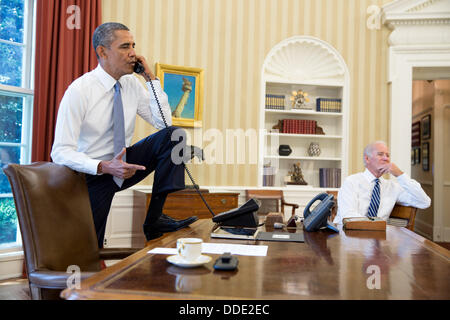 US-Präsident Barack Obama spricht am Telefon im Oval Office mit Sprecher des Hauses John Boehner über die Situation in Syrien als Vize-Präsident Joe Biden 31. August 2013 in Washington, DC hört. Stockfoto