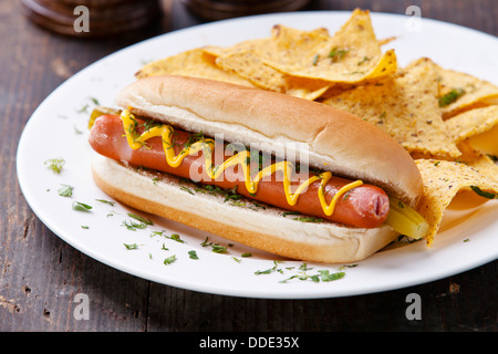 Hot Dog mit Senf und Kartoffel-Chips auf hölzernen Hintergrund Stockfoto