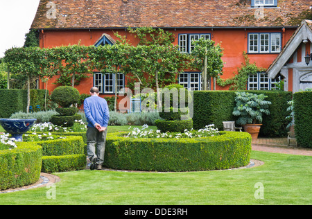Mann zu Fuß in die Gärten an Wyken Hall, elisabethanische Herrenhaus in Suffolk, England. Stockfoto