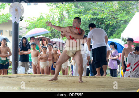 Ringer und Babys nehmen Teil in einem Sumo-Event am Matsuo Taisha Schrein in Kyoto, Japan. Stockfoto