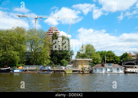 Eine qualitativ hochwertige Gehäuse und Hotel Neuentwicklung, Kingston Riverside, thront über Hausboote in Kingston Upon Thames. Stockfoto