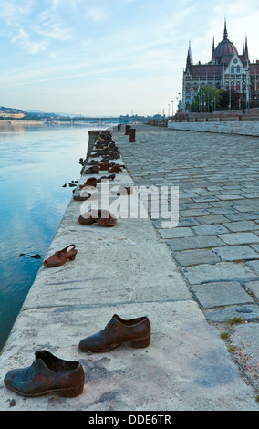 Ungarische Wahrzeichen, Budapester Parlament (rechts) und Monument (The Shoes an der Donau-Promenade) Stockfoto