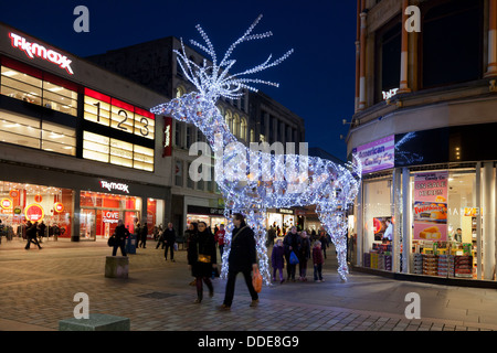 Beleuchtetes Rentier, Bestandteil der Weihnachtsschmuck in Argyle Street, Glasgow, Schottland, mit Passanten und Shopper. Stockfoto