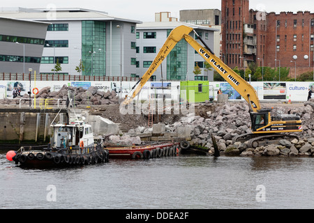 Im Gange sind Arbeiten zur Reparatur des eingestürzten Gehwegs am Anderston Quay am Fluss Clyde mit einem Bagger, Schlepper und einem Lastkahn in Glasgow, Schottland, Großbritannien Stockfoto