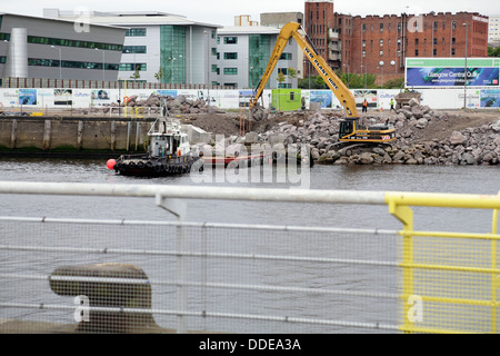 Im Gange sind Arbeiten zur Reparatur des eingestürzten Gehwegs am Anderston Quay am Fluss Clyde mit einem Bagger, Schlepper und einem Lastkahn in Glasgow, Schottland, Großbritannien Stockfoto