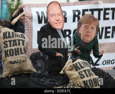 Berlin-Adlershof, Deutschland. 01. September 2013. Demonstranten tragen Masken von Bundeskanzlerin Angela Merkel und SPD-Spitzenkandidat Peer Steinbrück, wie sie vor der Wahl Fernsehduell vor dem TV-Studio in Berlin-Adlershof, Deutschland, 1. September 2013 protestieren. Foto: KAY NIETFELD/Dpa/Alamy Live News Stockfoto