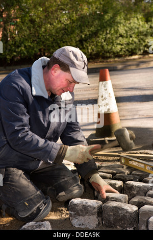 selbst bauen, Haus, harte Landschaftsbau, Arbeiter verlegen zurückgefordert Granit Pflastersteine am Eingang Einfahrt Stockfoto