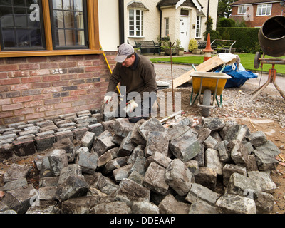 selbst bauen, Haus, harte Landschaftsbau, Arbeiter verlegen zurückgefordert Granit Pflastersteine um Neubau nach Hause Stockfoto