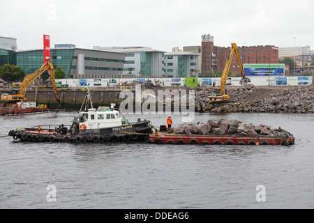 Im Gange sind Arbeiten zur Reparatur des eingestürzten Gehwegs am Anderston Quay am Fluss Clyde mit einem Bagger, Schlepper und einem Lastkahn in Glasgow, Schottland, Großbritannien Stockfoto