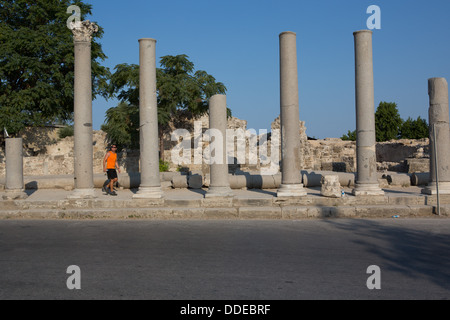 Ein Mann geht zu den großen zerstörten stützen eine römische Säulenstraße in Side, Türkei. Stockfoto