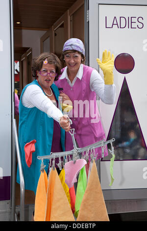 Kendal, Cumbria, Großbritannien. August 2013. Toilettenreinigerinnen 'Stars of the Lavatory' Andrea Neumann und Rike Radloff, Komödie aus Deutschland im kleinsten Raum beim Mintfest Street Arts Festival 2013, Ein Lakes Alive Wochenendevent im Lake District mit Künstlern aus der ganzen Welt, die kostümierte Comedy-Acts im Stadtzentrum von Kendal aufführten. Quelle: Cernan Elias/Alamy Live News Stockfoto