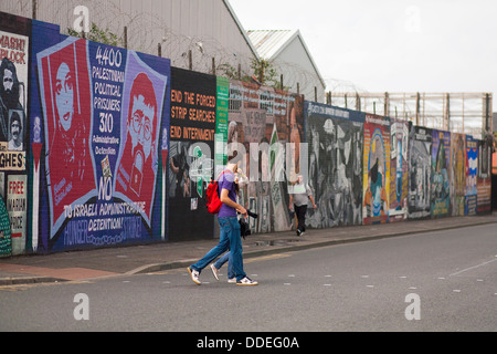 Politische Wandmalereien bemalt bunt an einer Wand in Belfast, Nordirland, wo Touristen besuchen, um die Geschichte zu entdecken. Stockfoto