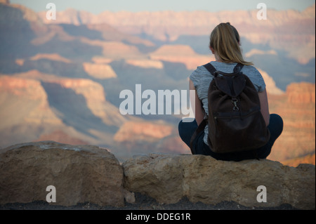 Junge Frau sitzt in Grand Canyon Stockfoto