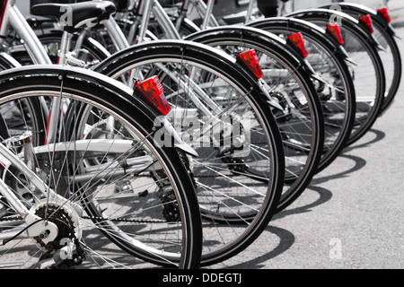 Fahrräder stehen in einer Reihe auf einem Parkplatz zu vermieten Stockfoto