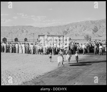 Evakuierten im Manzanar Relocation Center, einem Internierungslager aus dem Zweiten Weltkrieg, werden bei einem Baseballspiel beobachtet. Diese Aktivität war Teil der Freizeitprogramme, die Internierten während ihrer Zeit im Lager zur Verfügung gestellt wurden. Stockfoto