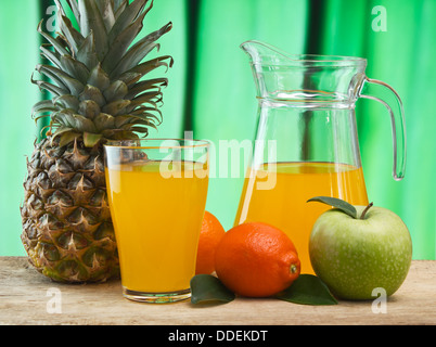 Auswahl an Obst und Saft auf einem Holztisch im Garten Stockfoto