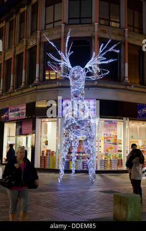 Beleuchtetes Rentier, Bestandteil der Weihnachtsschmuck in Argyle Street, Glasgow, Schottland, mit Passanten und Shopper. Stockfoto