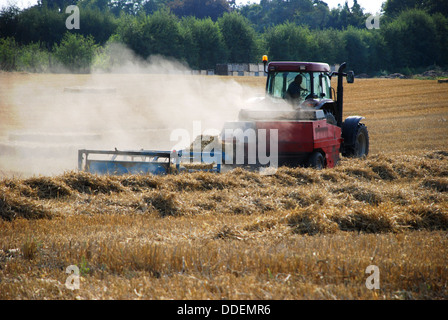 Roter Traktor Ballen Stroh auf dem Lande Stockfoto