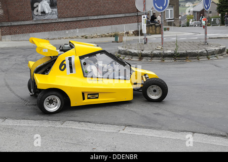 Gelb racing Buggy driften in einer Kurve auf einer Asphalt-Strecke. Slalom-Rallye in Marchin, Belgien Stockfoto