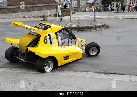 Gelb racing Buggy driften in einer Kurve auf einer Asphalt-Strecke. Slalom-Rallye in Marchin, Belgien Stockfoto