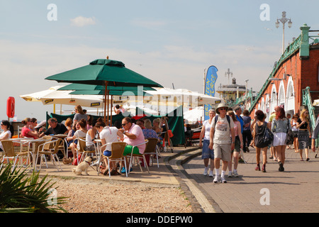 Cafés und Menschen am Strand von Brighton direkt am Meer und Promenade East Sussex England UK Stockfoto