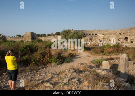 Ein Tourist fotografiert von Roman Amphitheatre, Side, Türkei. Stockfoto