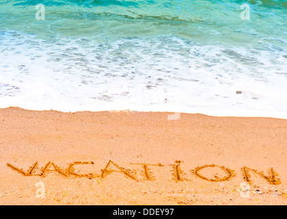 Urlaub; geschrieben in den Sand auf den Strand blauen Wellen im Hintergrund Stockfoto