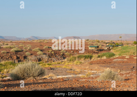 Aride Landschaft mit Zelt und eine Feder am Palmwag Lodge, Kunene-Region, Namibia Stockfoto