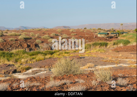 Aride Landschaft mit Zelt und eine Feder am Palmwag Lodge, Kunene-Region, Namibia Stockfoto