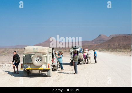 Gruppe von Reisenden mit 4WD Fahrzeuge und Anhänger auf einer staubigen Straße in der Erongo Region, Namibia Stockfoto