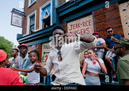 Menschen genießen den Notting Hill Carnival außerhalb geschlossen Stammtischen Stockfoto