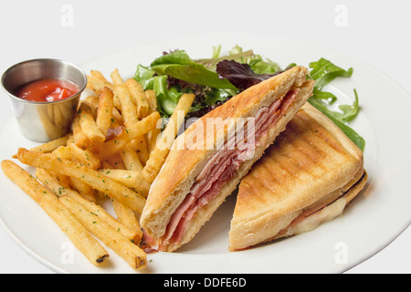 Panini mit in Scheiben geschnittenen Schinken Kartoffel Pommes frites Bio grüner Salat und Ketchup Closeup Stockfoto