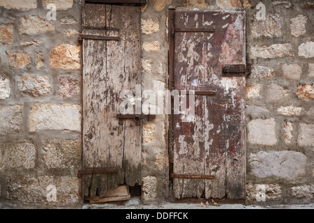 Alte Holztüren in grauen Steinwand gesperrt. Perast Stadt, Montenegro Stockfoto